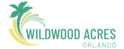 Logo for Wildwood Acres Orlando featuring a green palm tree and curved lines in green, yellow, and blue, forming a semi-circle. The text is in teal and light green on a white background.