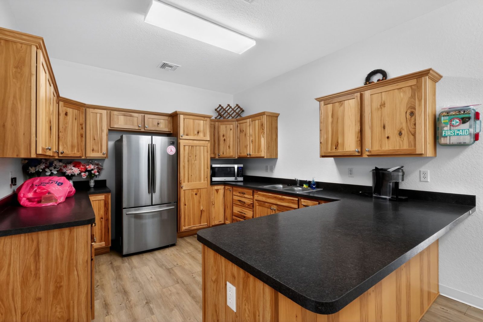 A kitchen with wooden cabinets and a stainless steel refrigerator.